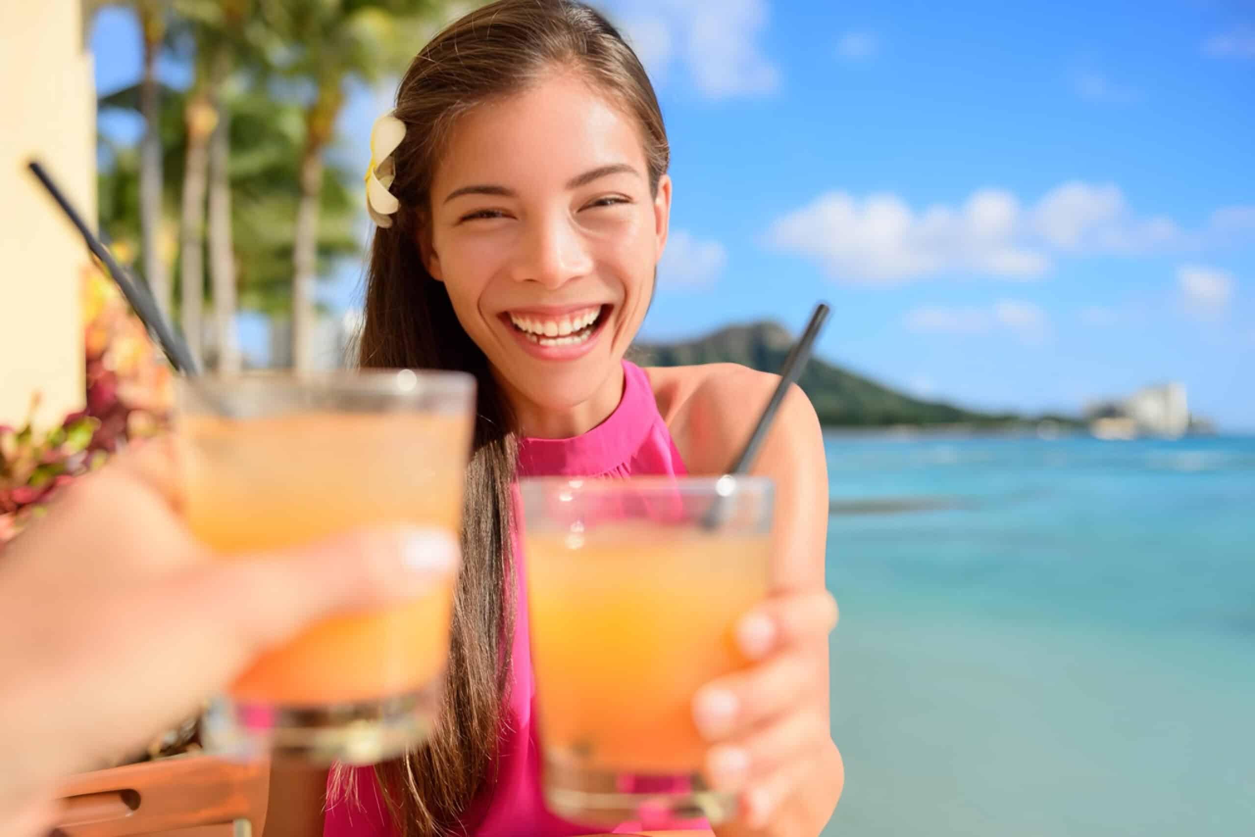 Woman smiling with drink in Hawaii, fundraising ideas, charity ideas, silent auction items, travel fundraising events