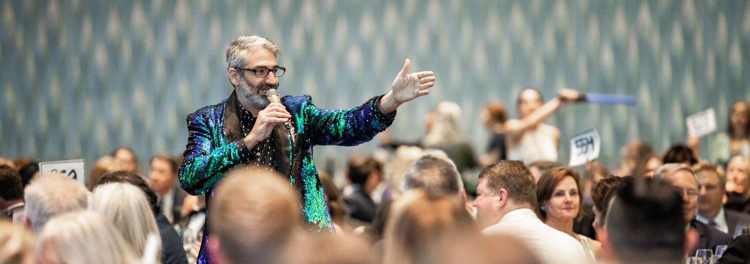 Man with microphone, fundraising ideas, charity ideas, silent auction items, travel fundraising events